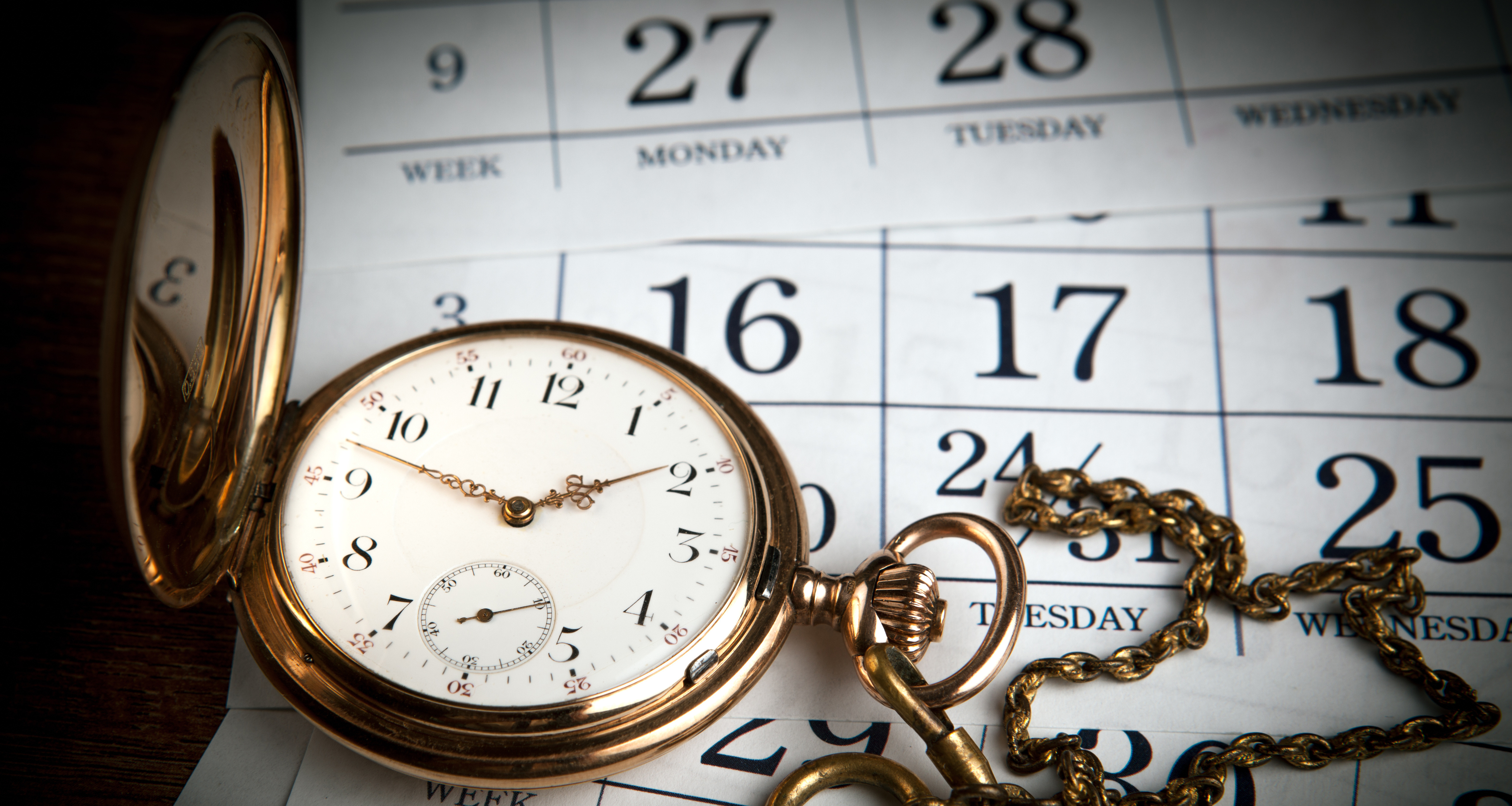 A pocket watch on calendar pages