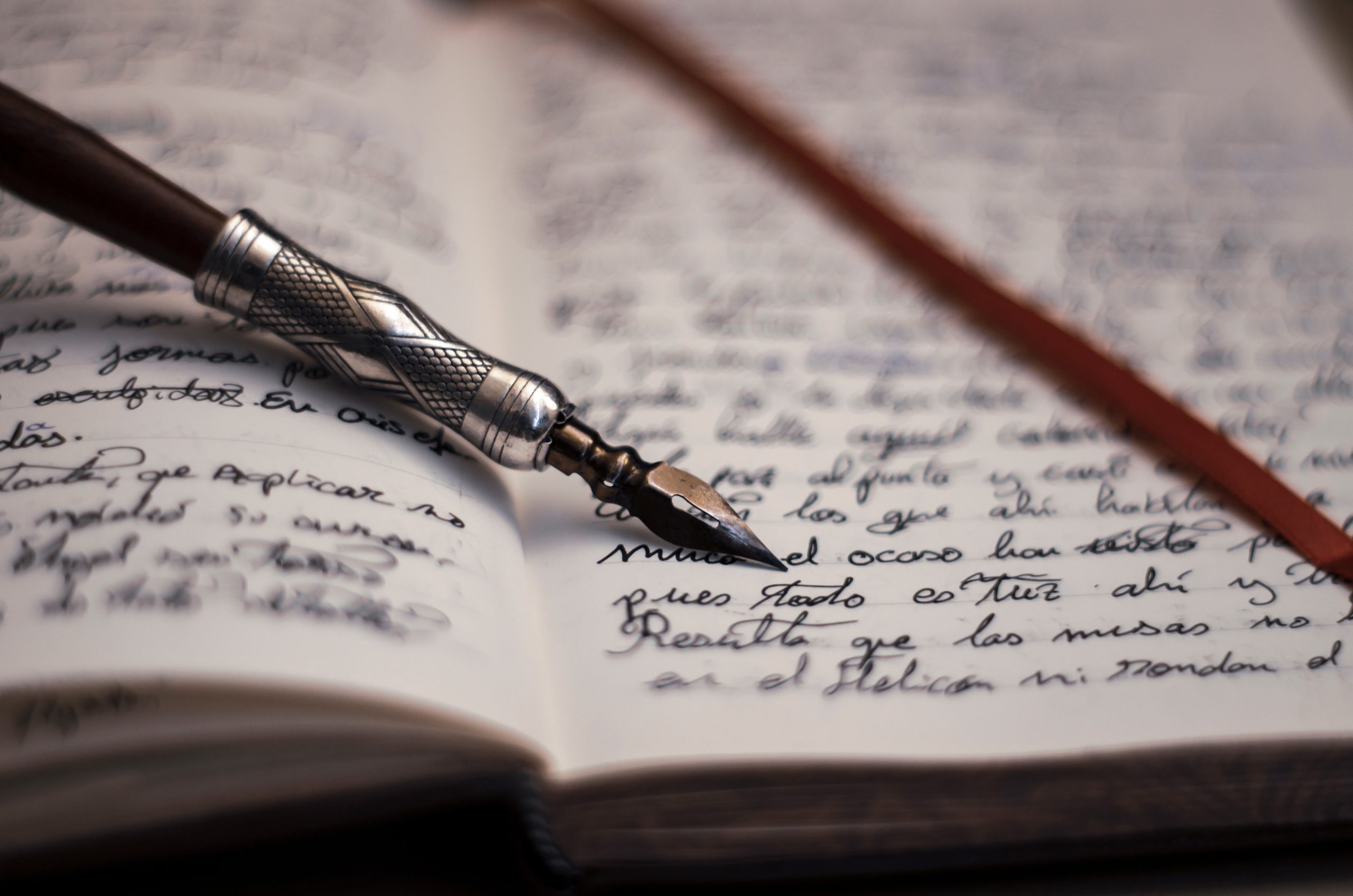 Opened book with beautiful calligraphy, handmade black ink and fountain pen