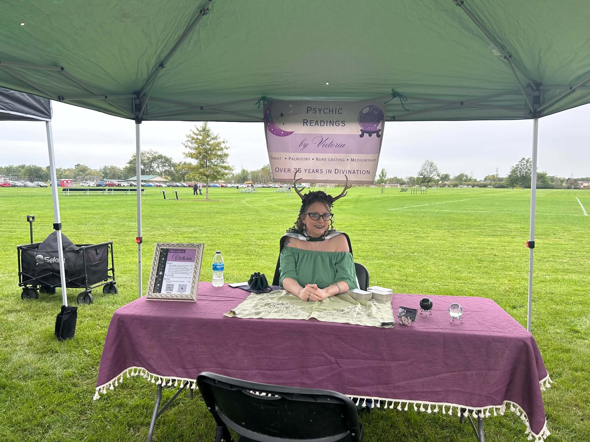 Victoria set up at an outdoor event with her table and tent.