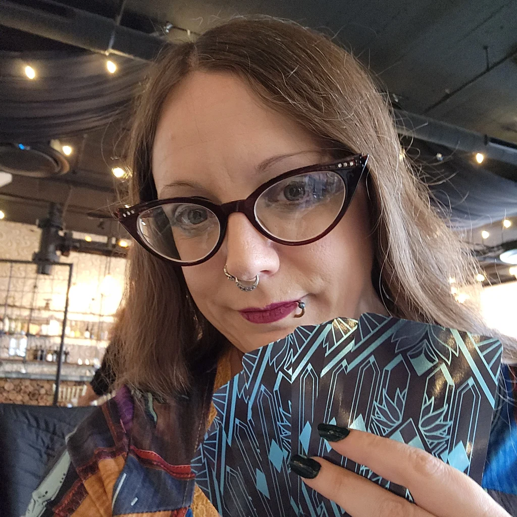 Victoria smiling and holding up a handful of tarot cards